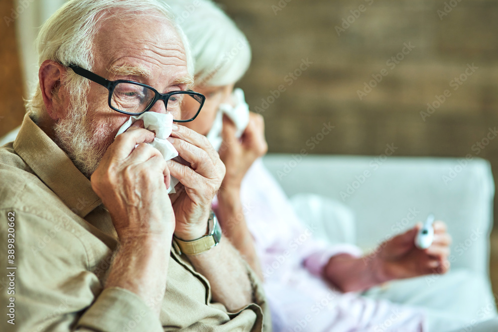 Male retiree using paper napkins for a cold Male retiree using paper napkins for a cold