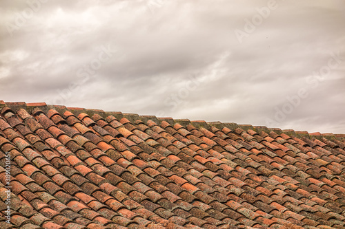 Roof of a house with cloudy sky.