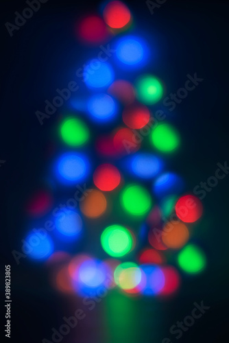 Christmas Abstract blurred pattern of light strands in purple tones as background. Christmas tree shape.