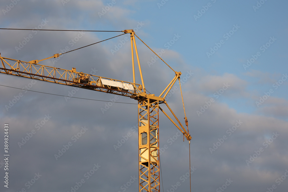 Crane at a construction site on a background of blue sky Crane at a construction site on a background of blue sky