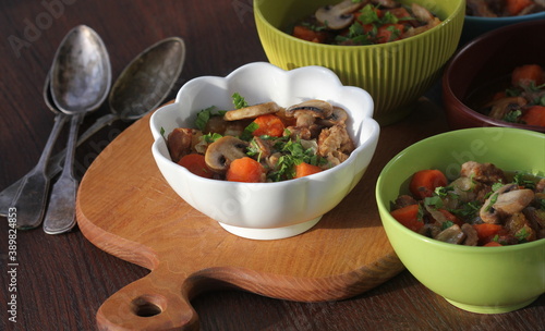 Meat stew with vegetable in bowl on rustic wooden background photo