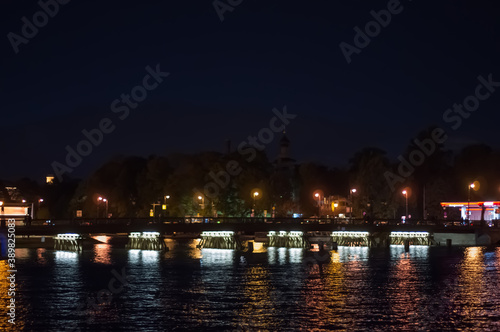 Illuminated bridge over the river at night. Blurry background photo. View of Saint Petersburg. © Aleksandr