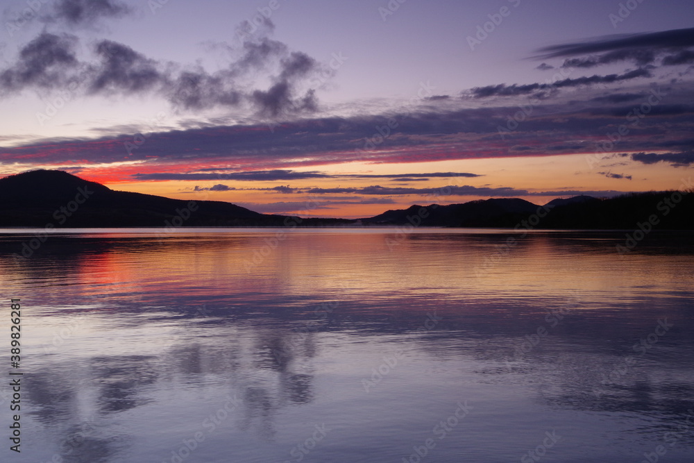 夜明けの空を湖面に映すカルデラ湖。屈斜路湖、北海道、日本。
