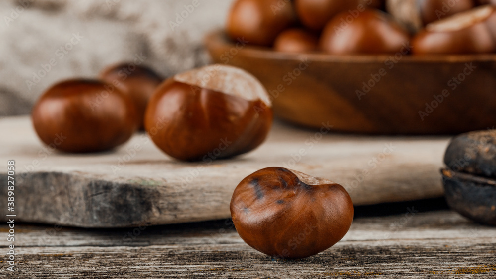 Obraz premium Chestnuts on an old wooden table