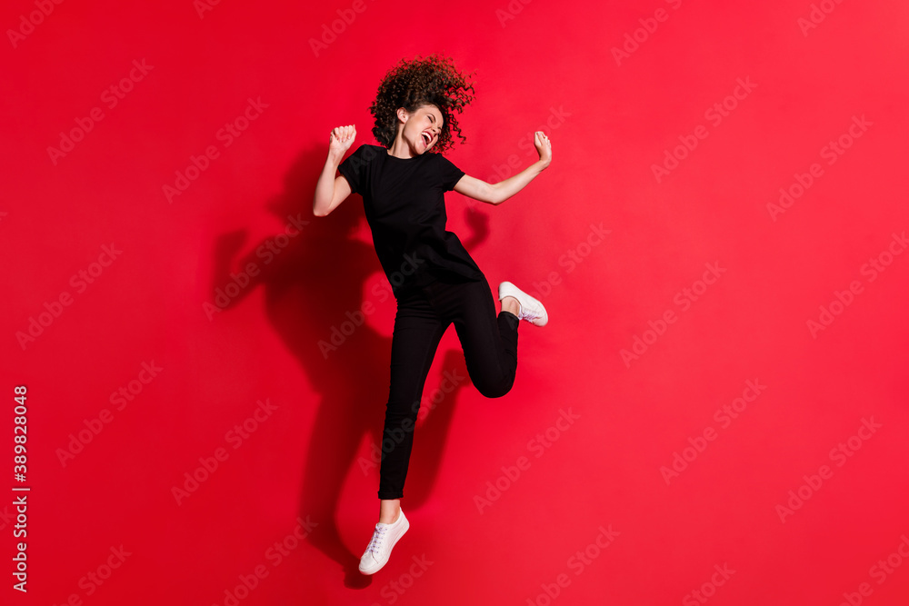 Photo portrait full body view of crazy girl dancing jumping up isolated on vivid red colored background Photo portrait full body view of crazy girl dancing jumping up isolated on vivid red colored background