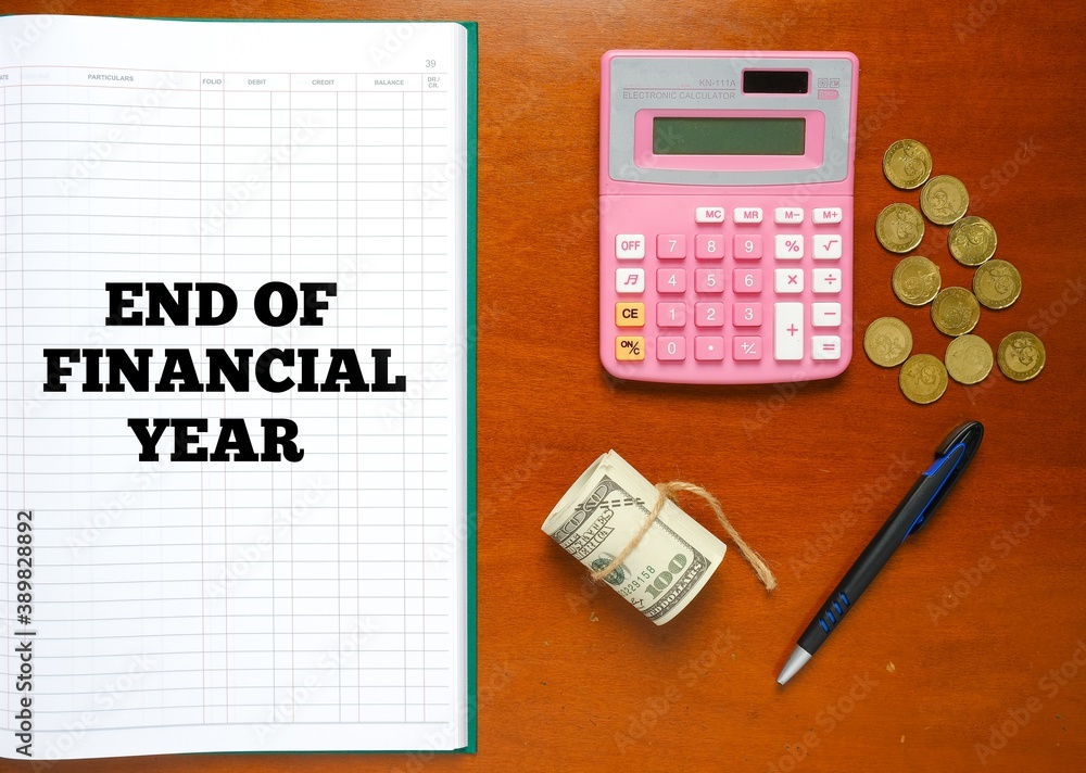 Flatlay picture of account manuscript book written End Of Financial Year with calculator, pen, fake cash and coin. Flatlay picture of account manuscript book written End Of Financial Year with calculator, pen, fake cash and coin.