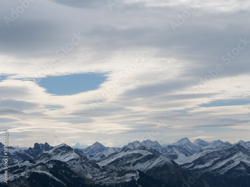 Panorama-Blick   ber die schneebedeckten Alpen in Tirol in   sterreich bei guter Fernsicht und leicht bew  lktem Himmel