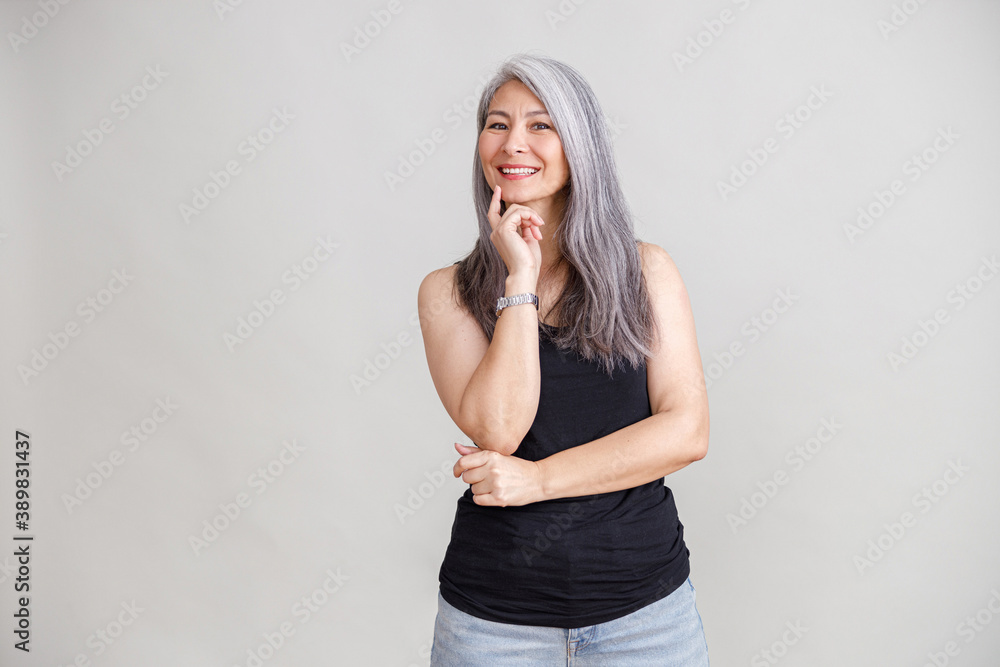 Emotional portraits of a paled long hair asian matured woman on grey background Emotional portraits of a paled long hair asian matured woman on grey background