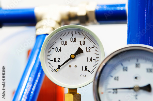 Mechanical barometer on the pipes of the heating system. Water pressure sensors in an industrial boiler room. Close-up