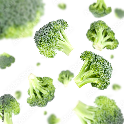 Many pieces of broccoli free falling on white background. Selective focus - shallow depth of field.