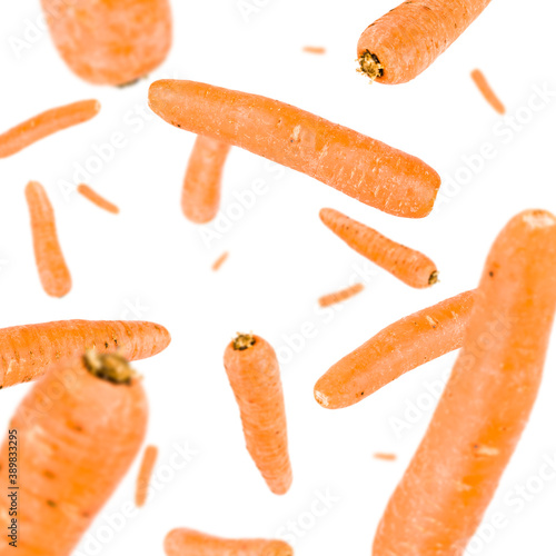 Many carrots free falling on white background. Selective focus - shallow depth of field.