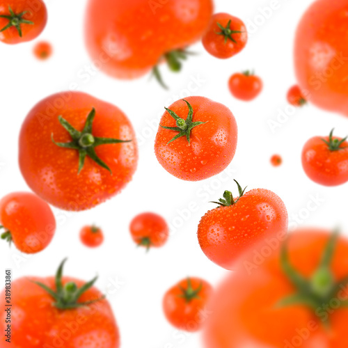 Many red tomatoes free falling on white background. Selective focus - shallow depth of field.