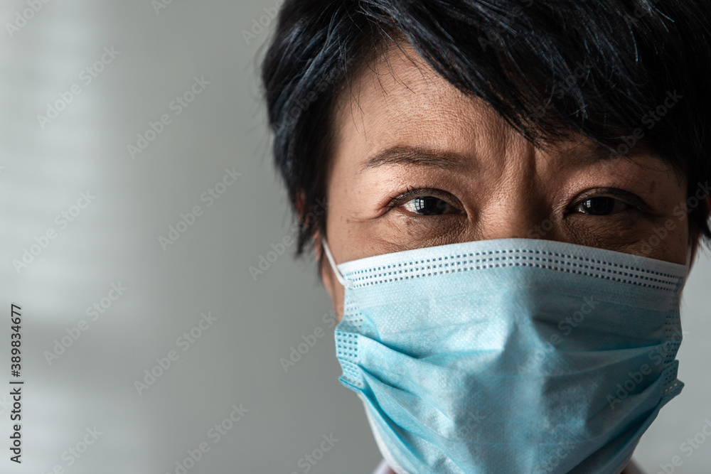 Close-up senior Asian woman wearing protective face during the Coronavirus crisis with a White Background. New normal and hygienic concept Close-up senior Asian woman wearing protective face during the Coronavirus crisis with a White Background. New normal and hygienic concept