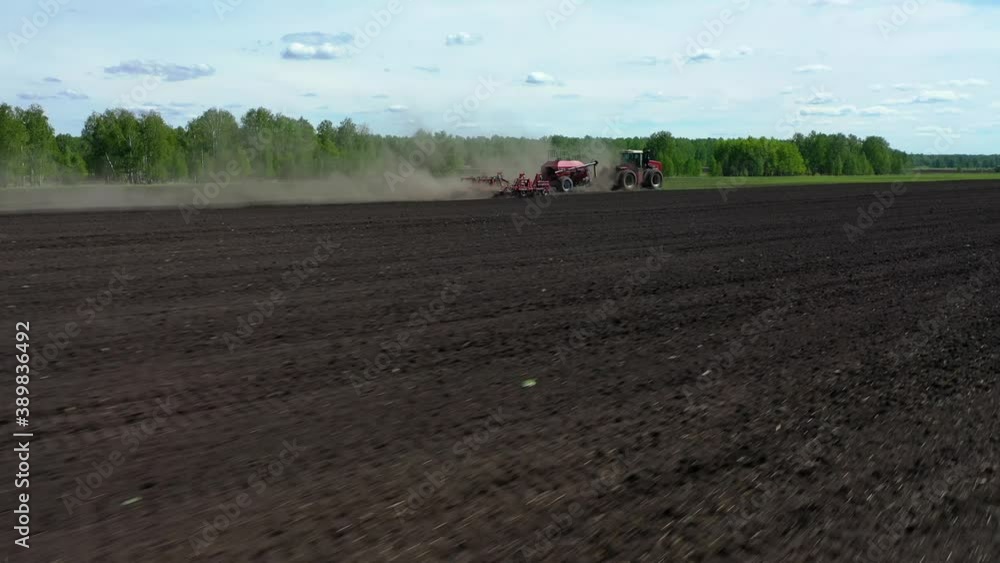 Tractor working in the field, sows grain Tractor working in the field, sows grain