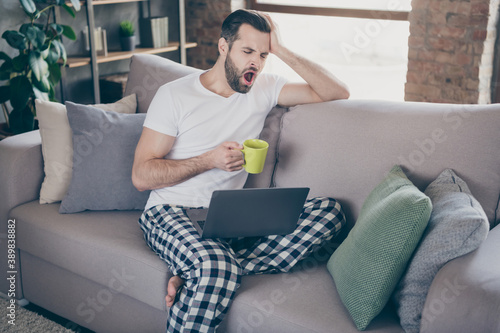 Foto Photo of handsome homey guy sit comfy sofa working morning drink fresh coffee ya