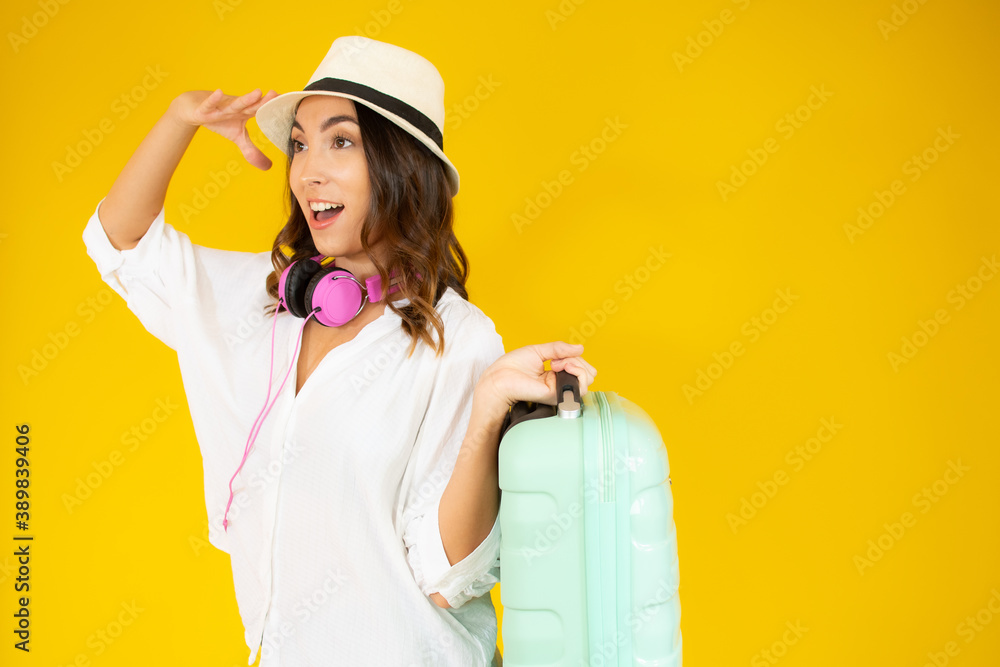 concept of travel. happy woman girl with suitcase on yellow colored background concept of travel. happy woman girl with suitcase on yellow colored background