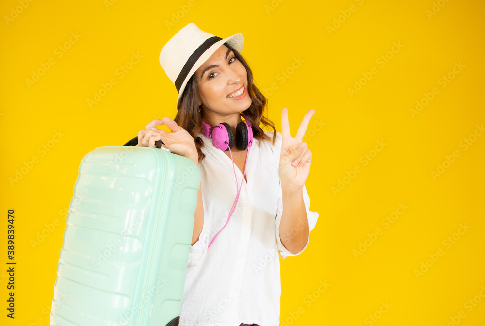 concept of travel. happy woman girl with suitcase on yellow colored background concept of travel. happy woman girl with suitcase on yellow colored background