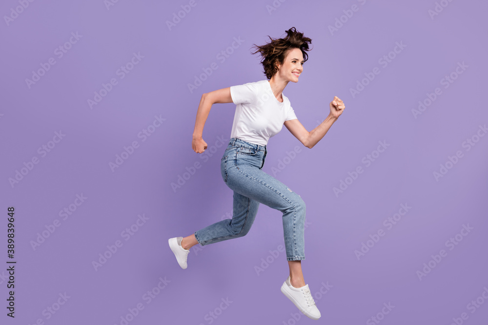 Full length body size side profile photo of girl running fast jumping high isolated on vibrant violet color background