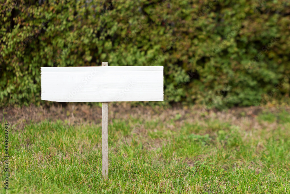 Blank mock up wooden sign in the garden. Concept for advertisement, guide board, tourism wood sign.