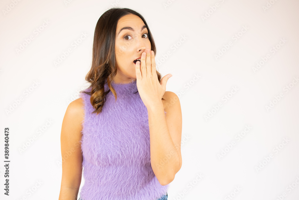 young woman in lilac shirt cover her lips and looking away at copy space.Waist up studio shot on white background. young woman in lilac shirt cover her lips and looking away at copy space.Waist up studio shot on white background.