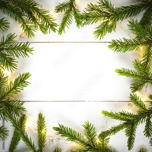 Christmas lights garland circular border and fir branches with copy space.