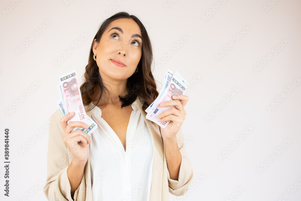 Portrait of a cheerful young woman holding money banknotes isolated over white background Portrait of a cheerful young woman holding money banknotes isolated over white background