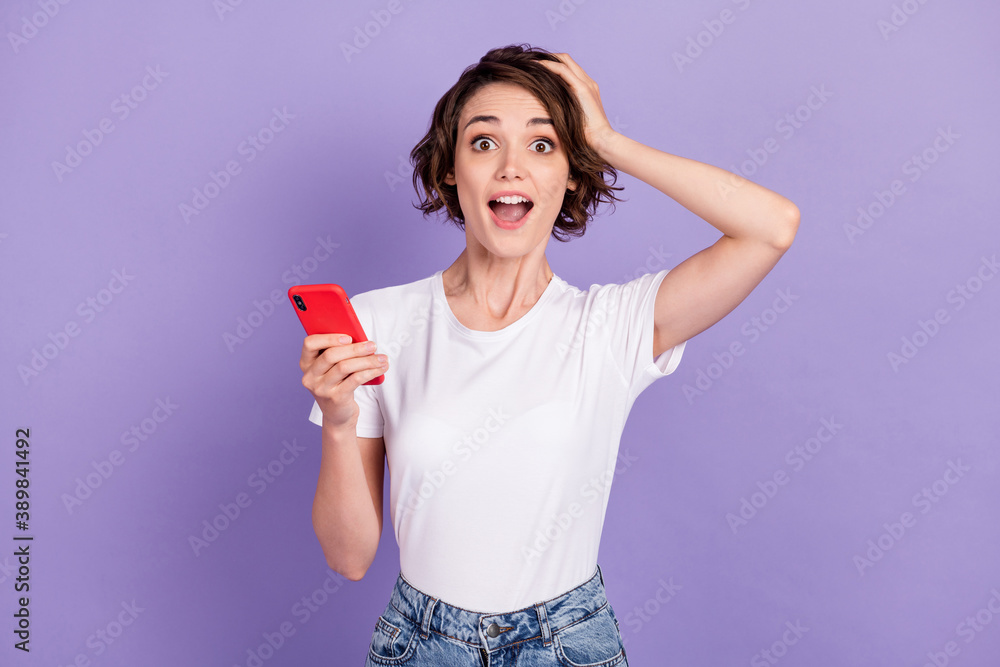 Photo portrait of shocked amazed girl with bob hair holding cellphone staring touching head isolated on vivid violet color background Photo portrait of shocked amazed girl with bob hair holding cellphone staring touching head isolated on vivid violet color background