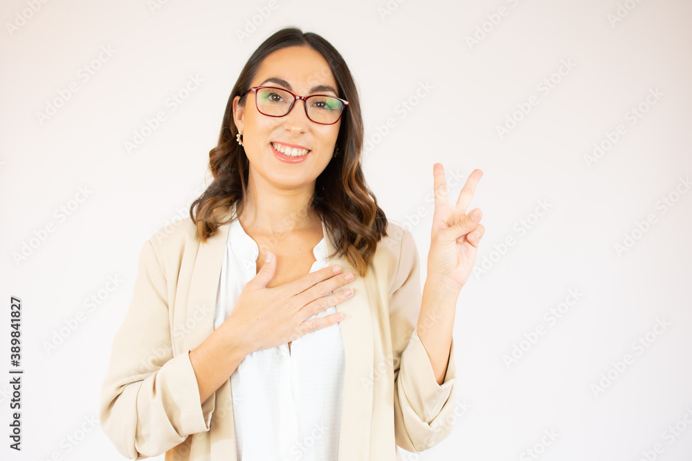 Portrait of a smiling happy woman showing victory sign and looking at camera isolated on the white background Portrait of a smiling happy woman showing victory sign and looking at camera isolated on the white background