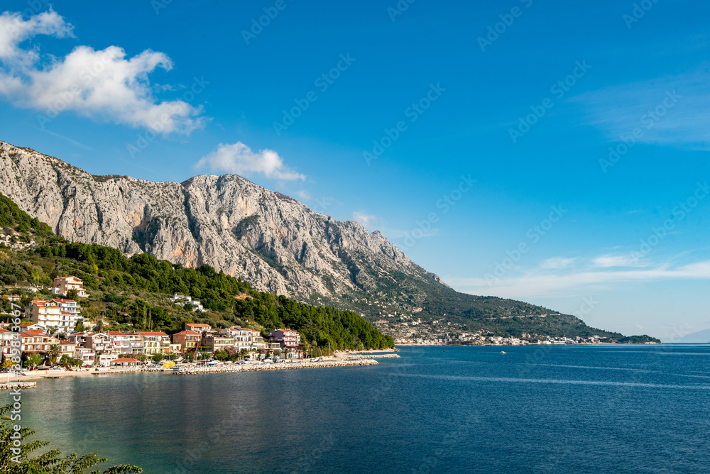 Amazing view at Makarska rivera beaches with apartments in Makarska Riviera. Podgora-Caklje area with high mountain Biokovo in background. Croatia, Dalmatia