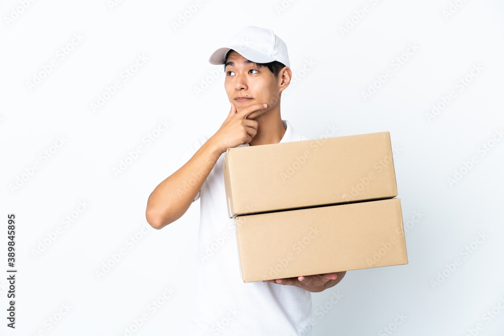Delivery Chinese man isolated on white background thinking an idea while looking up Delivery Chinese man isolated on white background thinking an idea while looking up