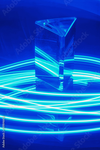 Glass Prism with reflection on a abstract blue neon stripey background