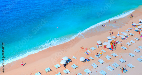 Fototapeta Naklejka Na Ścianę i Meble -  Holidaymakers sunbathing at Kaputas beach - Clear water sea and orange sand beach - Colorful Hot Summer Landscape of Kaputas Beach - Antalya Turkey