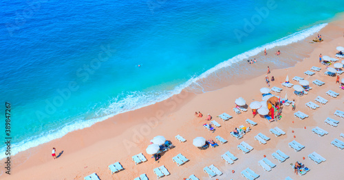 Holidaymakers sunbathing at Kaputas beach - Clear water sea and orange sand beach - Colorful Hot Summer Landscape of Kaputas Beach - Antalya Turkey © muratart