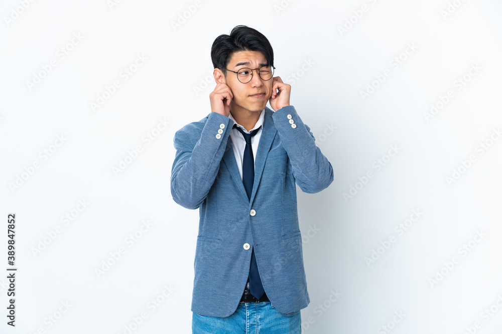Young Chinese business man isolated on white background frustrated and covering ears Young Chinese business man isolated on white background frustrated and covering ears
