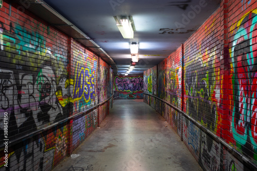 Abandoned underground passage with bright orange graffiti 