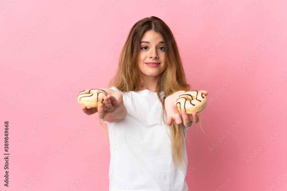 Young blonde woman isolated on pink background holding a donut and sad Young blonde woman isolated on pink background holding a donut and sad