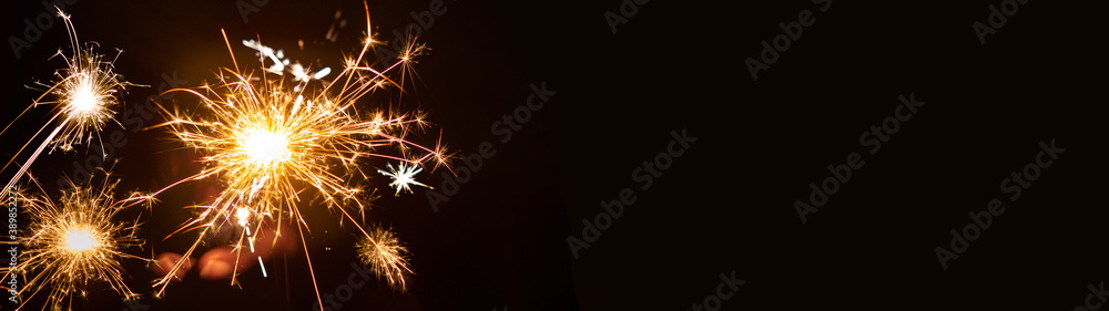 Silvester / New year background - People hold sparkling sparkler in her hand at dark night