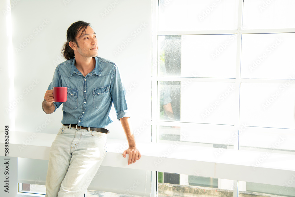 Man standing smile in the morning with red cup of coffee in his hand Man standing smile in the morning with red cup of coffee in his hand