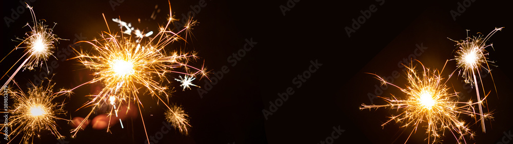 Silvester / New year background banner  panorama - People hold sparkling sparkler in her hand at dark night - obrazy, fototapety, plakaty 