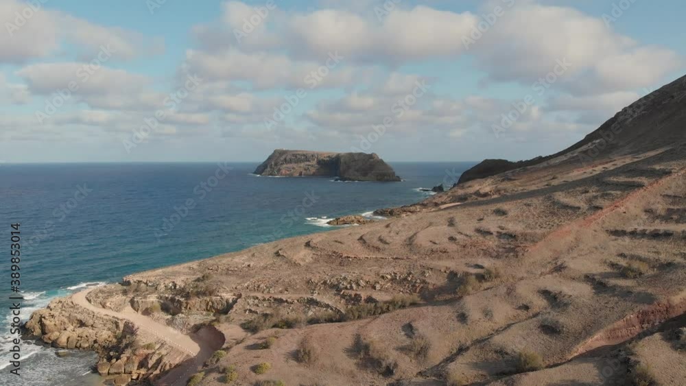 The northern cliff edged shore of Porto Santo and a remote road with another island in the distance. The northern cliff edged shore of Porto Santo and a remote road with another island in the distance.