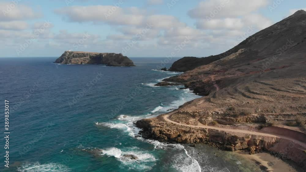 A winding road on Porto Santo with islands and clouds on the horizon. A winding road on Porto Santo with islands and clouds on the horizon.