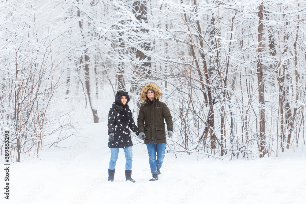 Young couple in love walks in the snowy forest. Active winter holidays. Young couple in love walks in the snowy forest. Active winter holidays.