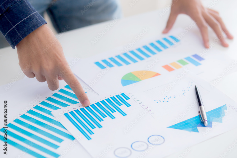 Hand of young business man pointing document data graph and chart paper, marketing and investment, report of statistics profit for financial, economic and growth of finance, management and planning.