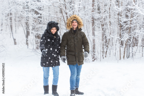 Young couple in love walks in the snowy forest. Active winter holidays. © satura_