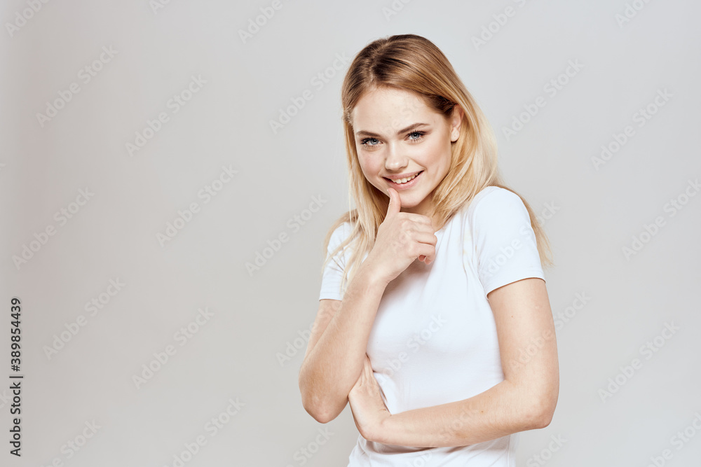 Cute blonde white t-shirt gesture with hands lifestyle light background Cute blonde white t-shirt gesture with hands lifestyle light background
