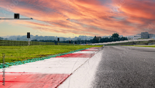Sunrise sky over asphalt straight track motorsport circuit scenic background curb surface level
