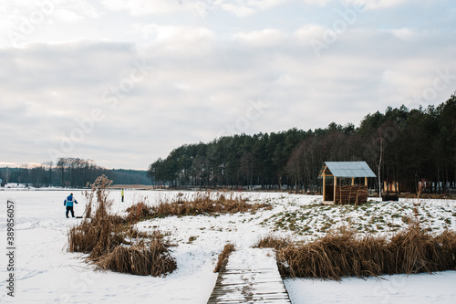 Wallpaper Mural A small bridge for winter fishing on the ice pond. Fishermen catch fish. Forest in near the lake. Torontodigital.ca