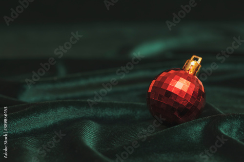 New Year card: Christmas ball on a green velvet background. Background for inscriptions and text.