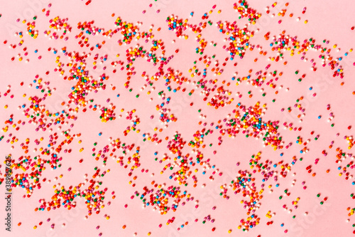 Festive mood, colored pastry sprinkles on a pink background