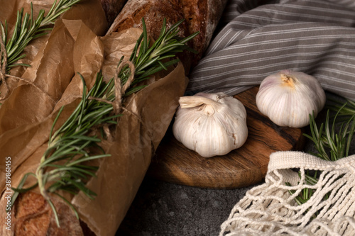 Whole wheat baguette, thyme and garlic on the table.